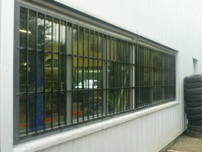 Verrière industrielle en acier sur la façade d'un bâtiment blanc